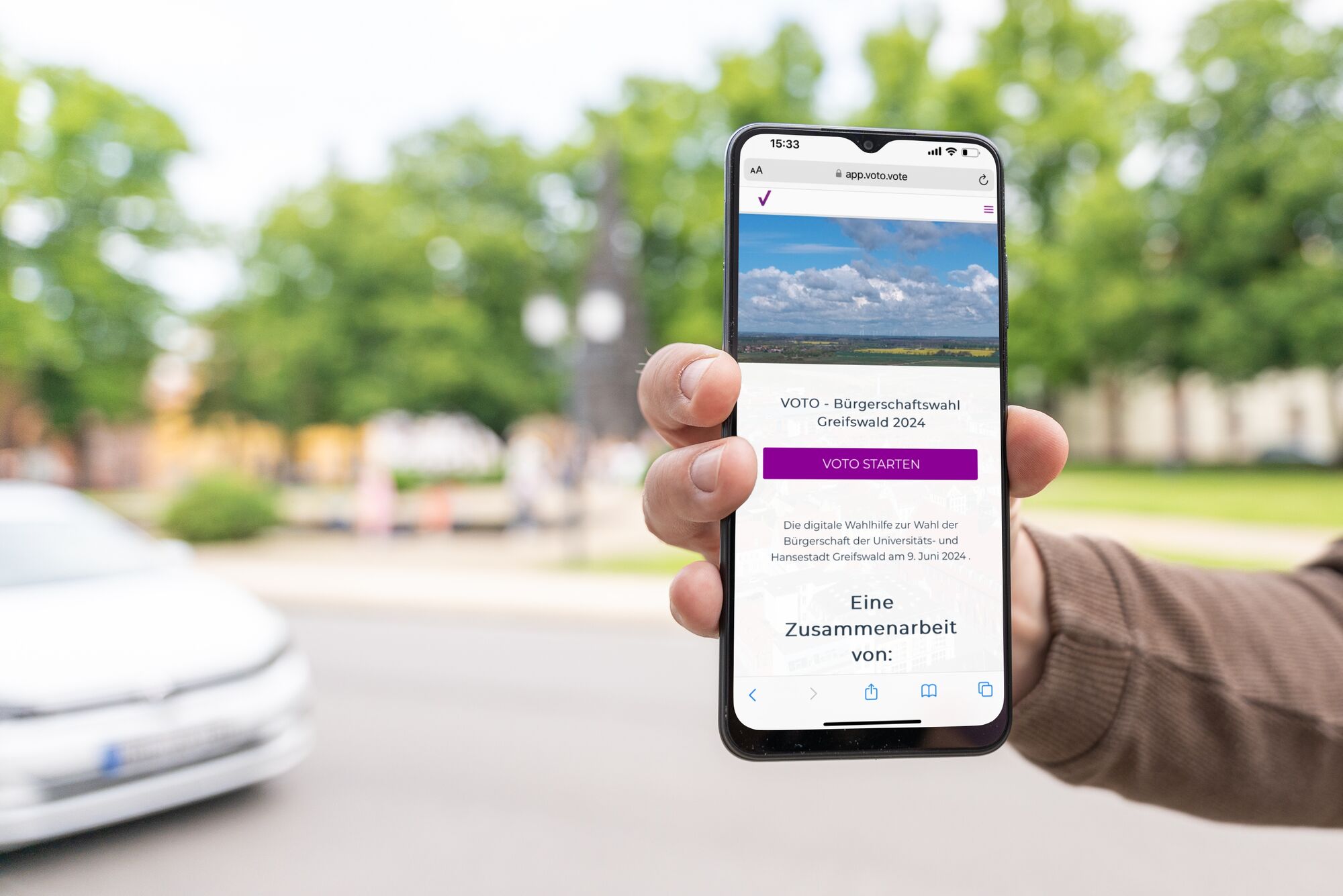 Ein Smartphone wird in die Kamera gehalten. Darauf ist die App der digitalen Wahlhilfe VOTO zu sehen.