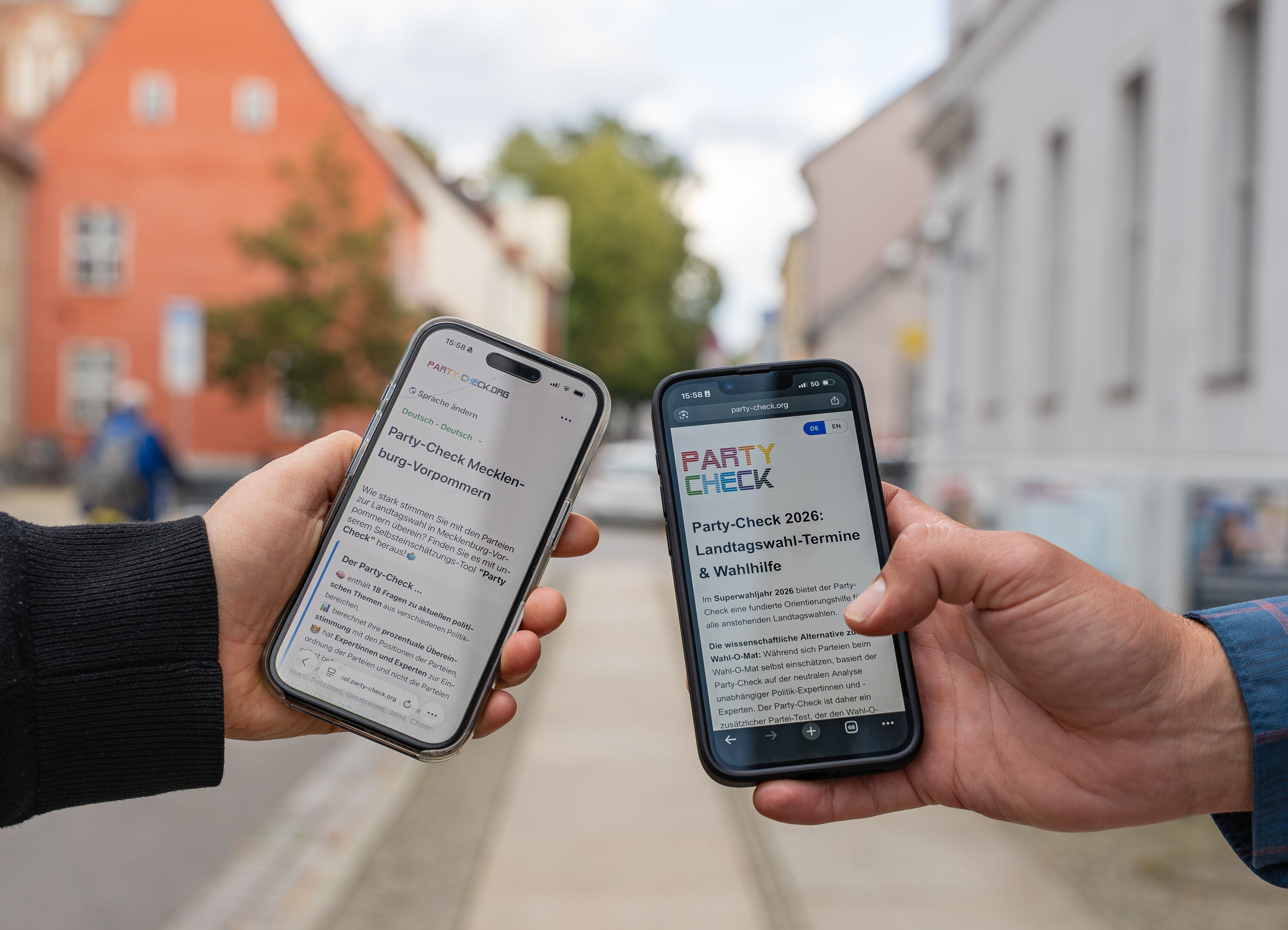 Die Onlinewahlhilfe-App auf dem Smartphone. Zu sehen sind jeweils eine Hand zweier Personen, die Smartphones halten.