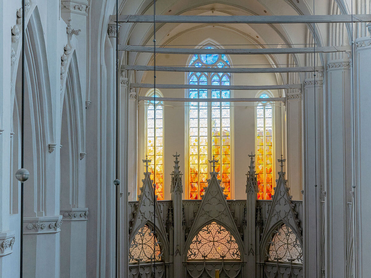 Die neugestalteten Fenster im Dom St. Nikolai leuchten gelb und orange.