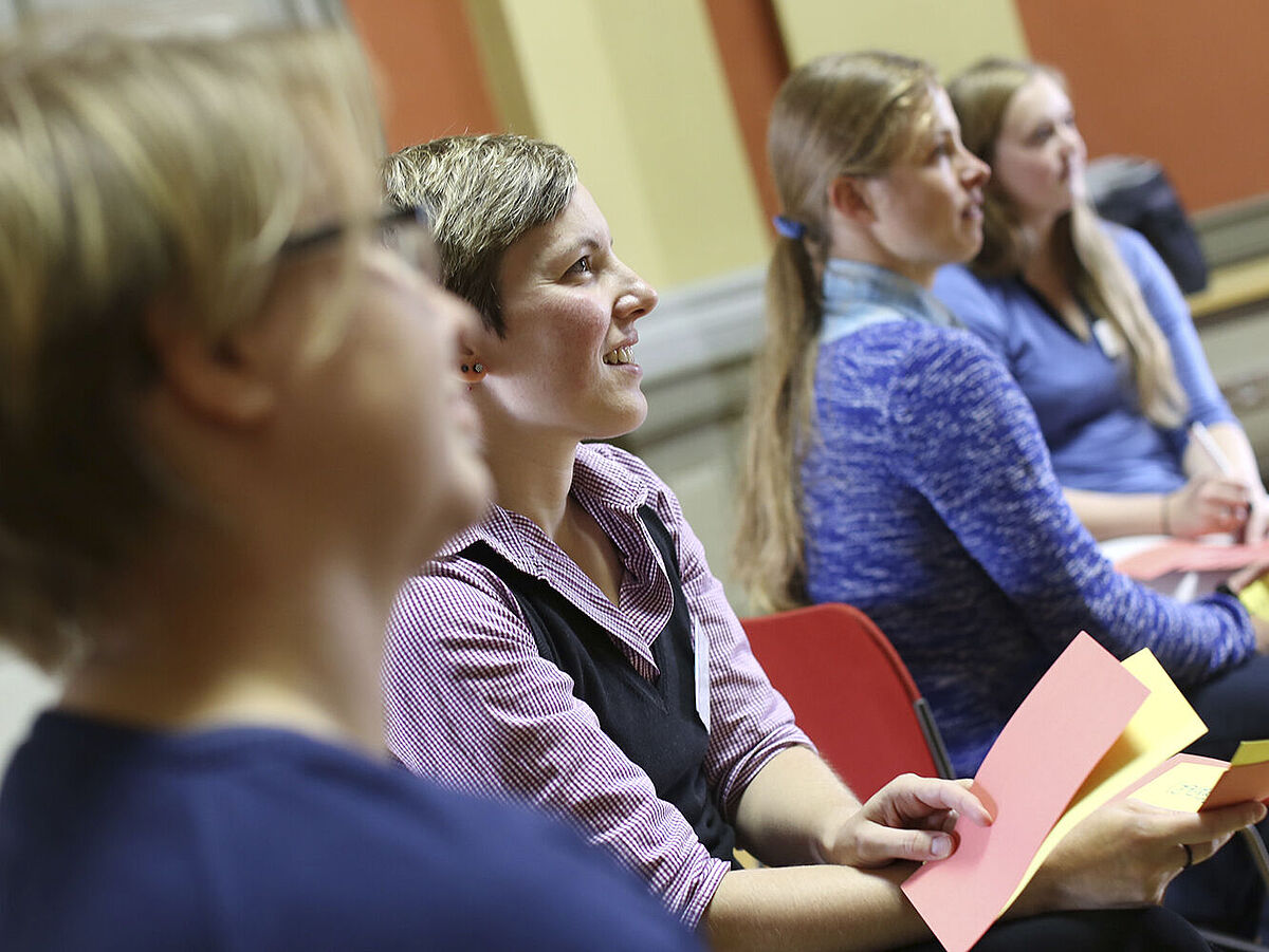 Vier weibliche Personen folgen während eines Meetings einem Vortrag.
