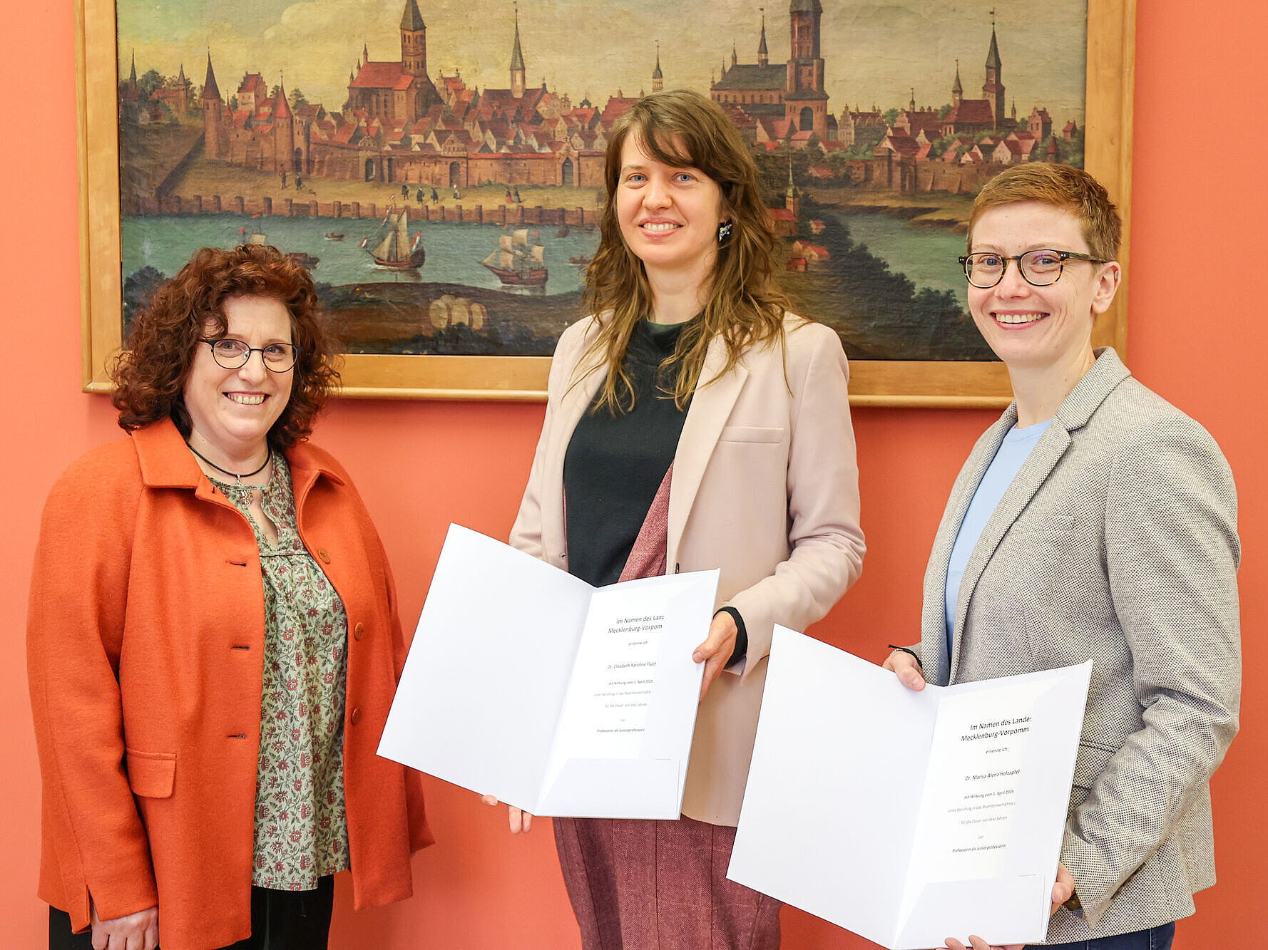 Junior-Prof. Dr. Elisabeth Flucher und Junior-Prof. Dr. Marisa Alena Holzapfel bekommen von Rektorin Prof. Dr. Katharina Riedel die Ernennungsurkunden überreicht. 