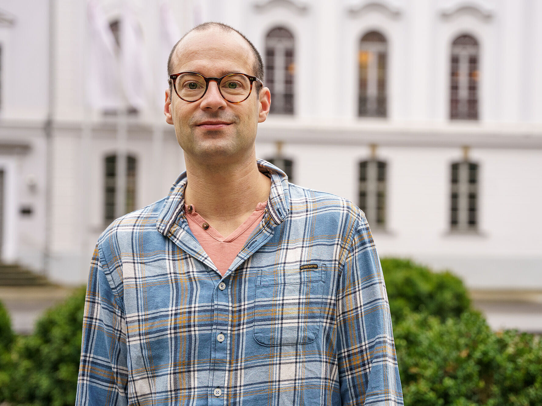Prof. Dr. Matthias Ludewig steht auf dem Rubenowplatz vor dem Unihauptgebäude.